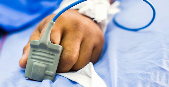 A patient critically ill with a Pulse Oximeter mounted on fingertip